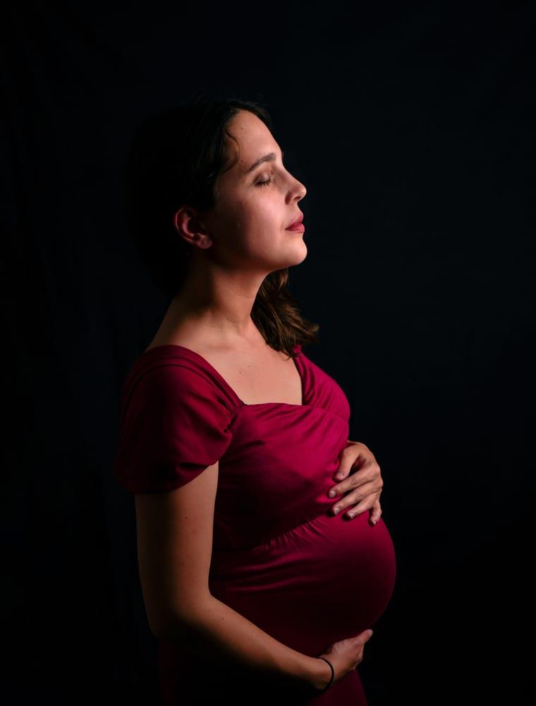 Portrait de grossesse en robe rouge, de profil